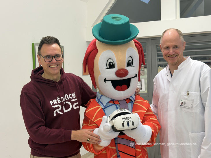 Markus Strobl von SO GEHT WOW - den Machern der Mixed-Reality-App „FrédARico RIDE“ mit FrèdARico und Prof. Jan Gödeke, stellvertretender Klinikdirektor der Kinderchirurgie und Professor für digitale Transformation(©Foto: Martin Schmitz) 